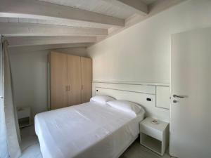 科利科Royal apt Colico Lake Como的白色卧室配有一张白色大床和橱柜