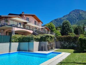科利科Royal apt Colico Lake Como的房屋前有游泳池的房子