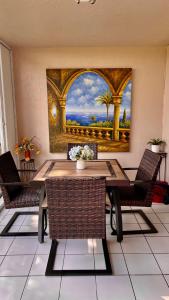 帕诺滩lovely 2BED 2BA vacation rental near the Beach的餐桌、椅子和墙上的绘画