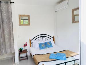 恩加帕鲁Keur Madior的一间卧室配有一张带蓝色枕头的床