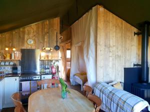 艾维布里奇Brackenhill Glamping - Safari Tent with Hot Tub - Sleeps 6的一间带桌子的房间和一个带沙发的厨房