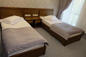 日托米尔Лісовий готель Гайки的卧室设有两张床、一张桌子和一个窗户。