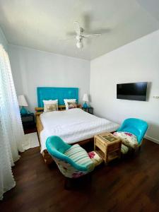 圣路易斯Chambre confortable dans une ambiance hôtel de charme avec piscine的一间卧室配有一张床和两张蓝色椅子