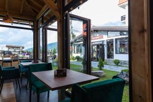 普雷代亚尔No 107 Predeal的餐厅设有绿色椅子、桌子和窗户