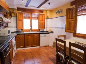 卡瓦内斯Holiday Home Rosa by Interhome的厨房配有木制橱柜和炉灶烤箱。