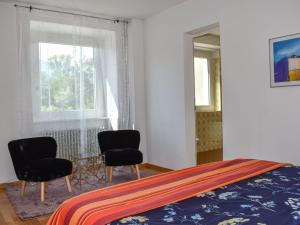 MagadinoApartment Le Bolle by Interhome的一间卧室配有两把椅子、一张床和窗户