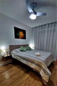 阿雷格里港Apartamento Top, 3 quartos, Wi-Fi 300 Mbps的一间卧室配有一张带吊扇的床