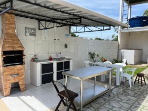 新艾朗Casa Boto Tucuxi 1的户外厨房配有桌椅