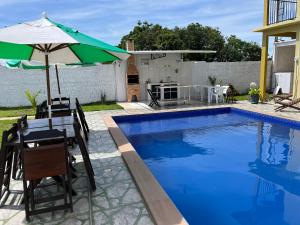 新艾朗Casa Boto Tucuxi 2的游泳池旁的桌子和遮阳伞