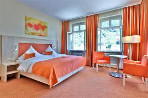 海德堡海德尔堡 城市伙伴酒店的一间卧室配有大床和橙色窗帘
