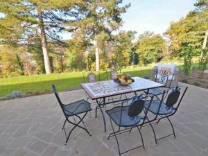 Osteria Delle NociHoliday Home VIlla Limone by Interhome的庭院桌椅和一碗水果
