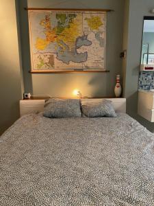 蒂伦豪特De Buitenmuur Guest House的卧室配有一张大床,墙上挂有地图