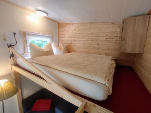 拉姆绍贝斯霍夫阿尔卑斯山酒店的木制客房内的一间卧室,配有一张床