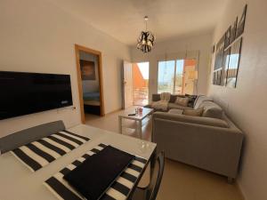 马萨龙El Alamillo ground floor apartment with sea view的客厅配有沙发和桌子