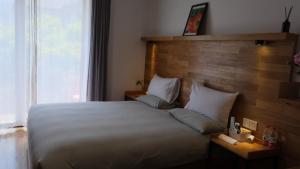 杭州闲处的卧室设有一张白色大床和一扇窗户。