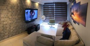 巴拿马城Navona Towers Amplio Apart, Dos Noches minimo, para 4 personas lo mejor de Panamá的带沙发和平面电视的客厅