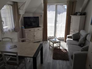 勒克鲁西克Appartement fonctionnel et chaleureux proche mer的客厅配有沙发和桌子