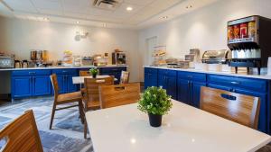 纽波特纽斯纽波特纽斯贝斯特韦斯特酒店的厨房配有蓝色橱柜和桌椅