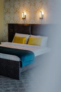 比哈奇HOTEL LOBBY的一间卧室配有黄色和蓝色枕头的床