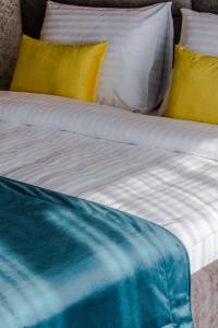 比哈奇HOTEL LOBBY的一张配有黄色和蓝色床单和枕头的床