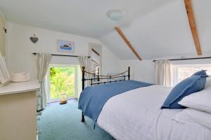 NancledraFinest Retreats - Waterside Cottage的一间卧室设有一张大床和一个窗户。