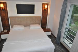 MackaJolnar garden hotel的一间卧室设有一张带平面电视的床。
