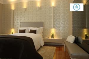 里斯本Castilho House的一间卧室配有一张大床和一张沙发