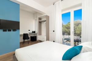 斯培西亚Nelli Rooms Via Veneto的卧室设有白色的床和大窗户