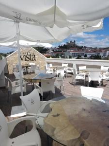 莫什港5ª Vigia的一个带桌椅和白色遮阳伞的庭院。