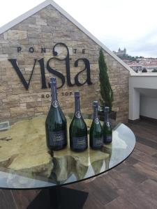 莫什港5ª Vigia的招牌前玻璃桌上四瓶葡萄酒