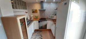 PauAppartement & Spa - Panoramic Olivars的小厨房配有白色橱柜和水槽