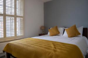 Kentcosy and peaceful near Ashford town centre的一间卧室配有一张带黄色床单和窗户的床。