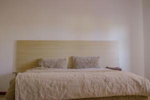 卢萨卡Carsi holiday Villa的一间卧室配有一张大床和木制床头板