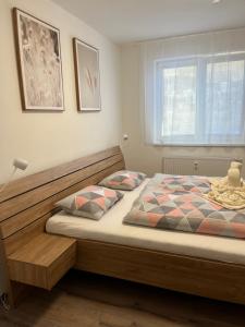 弗林布尔克Nový Apartmán v areálu Wellness hotelu Frymburk的一间卧室配有一张带木制床头板的床和窗户。