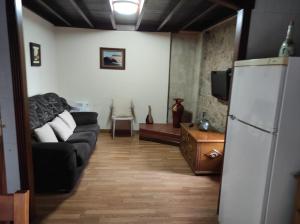 卡尔诺塔Casa de Xusto的客厅配有黑色沙发和冰箱