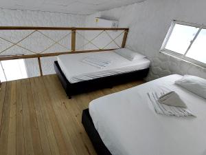 科韦尼亚斯Hotel Cabaña Playa DanRay的带2扇窗户的客房内的2张单人床