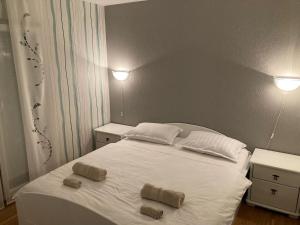 扎达尔Apartmani Lovre i Zara的卧室配有白色的床和2条毛巾