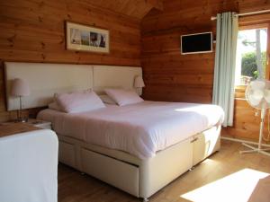 惠茨特布尔Hillview Bed and Breakfast的卧室配有一张床铺,位于带木墙的房间内