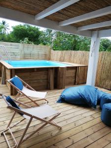 厄唐萨雷Cottage Tropical的一个带游泳池、两把椅子和一张桌子的甲板