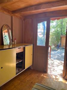 穆然Les roulottes de Bayama - logement insolite avec jacuzzi的一间黄色橱柜和门的房间