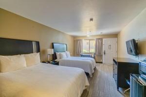 奥克赫斯特The Oakhurst Inn at Yosemite的酒店客房设有两张床和一台平面电视。
