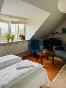 StenstrupDobbeltværelse i smuk palævilla的阁楼间设有两张床、一张沙发和一张桌子。