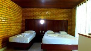 巴拉多库努Pousada do Forte的砖墙客房的两张床