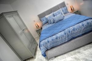 克里基厄斯Criccieth- STUDIO GLAN ERIN BACH的一间卧室配有一张带蓝色棉被的床
