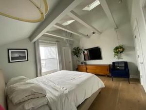 旧金山Beautiful 3 Bed 3 Bath upper house in Bernal Glen的一间卧室配有一张床、一张书桌和一台电视