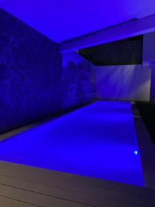PombasHotel Château Georgette的蓝色灯光的房间的游泳池
