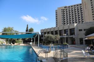 耶路撒冷Jerusalem Hotel Private Luxury Suites near Western Wall的大楼前的游泳池