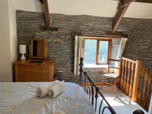 卡迪根特洛蒂赖假日酒店的一间卧室设有一张床和石墙
