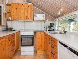 埃贝尔托夫特6 person holiday home in Ebeltoft的一个带木制橱柜和水槽的厨房