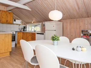 埃贝尔托夫特6 person holiday home in Ebeltoft的厨房配有白色的桌椅